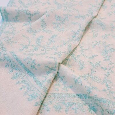 Découvrez la douceur et le raffinement de l’étole en Pashmina Tropiques, une pièce d’exception réalisée à la main dans la plus pure tradition artisanale de l’Himalaya. Son champ, délicatement tissé à œil de perdrix, arbore une teinte écrue naturelle et apaisante, rehaussée par une broderie gracieuse et minutieuse.